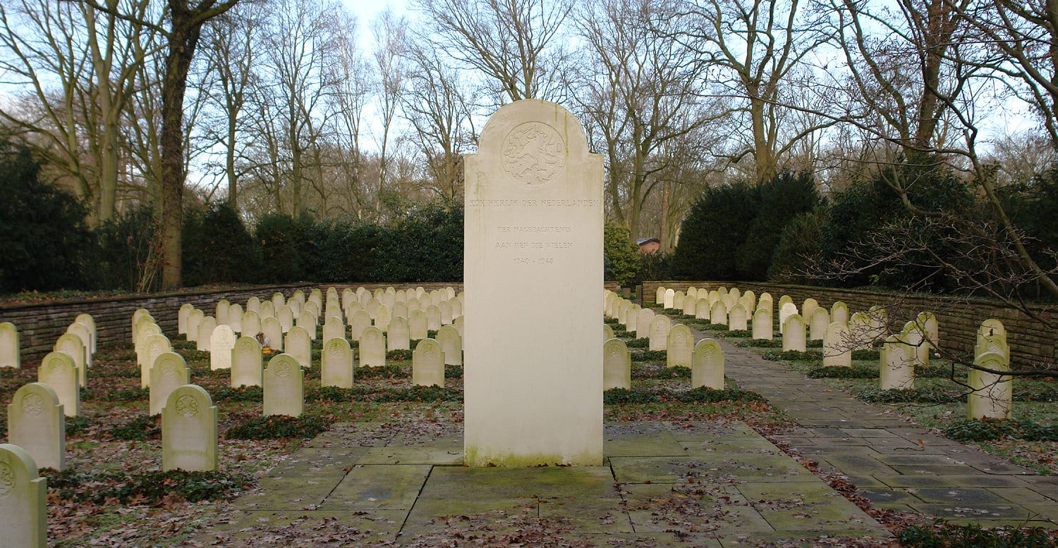 Zentraler Gedenkstein mit niederländischer Inschrift vor Reihen heller Grabsteine auf Osterholzer Friedhof